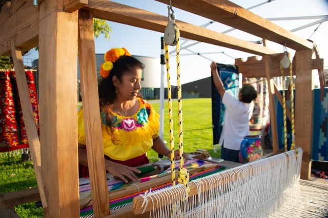 Oxacana Weaver Benita Martinez weaving at her loom in an open air market